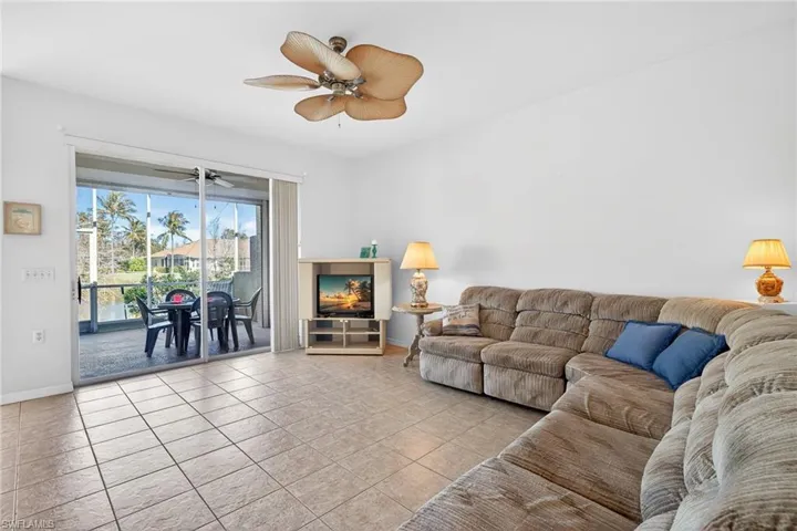 Living area featuring ceiling fan and light tile patterned flooring