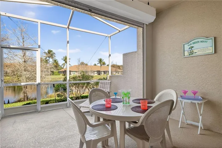 Sunroom with outdoor dining area and a water view