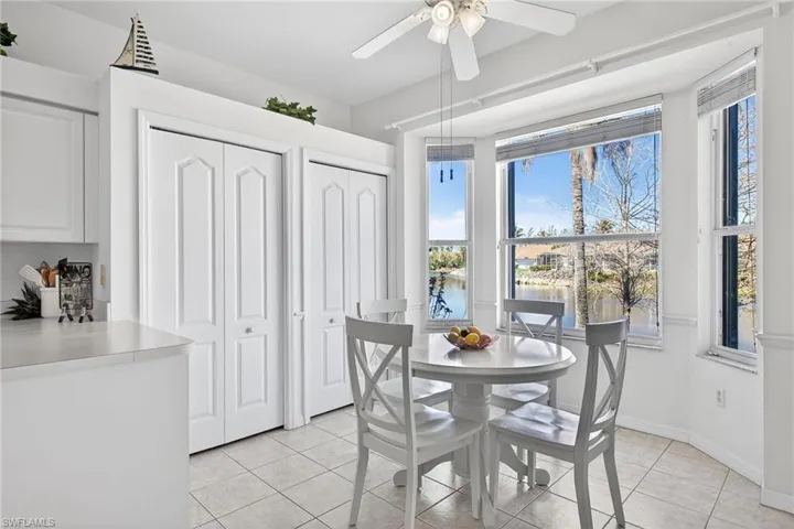 Dining space with a water view, ceiling fan, and light tile patterned floors