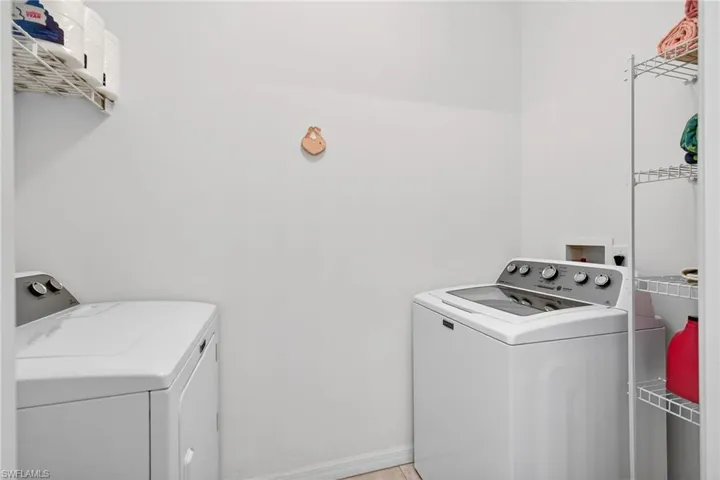 Laundry area featuring washing machine and dryer and baseboards