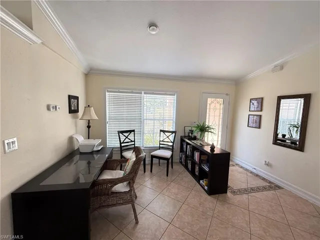 Home office featuring light tile patterned flooring, ornamental molding, and a textured ceiling