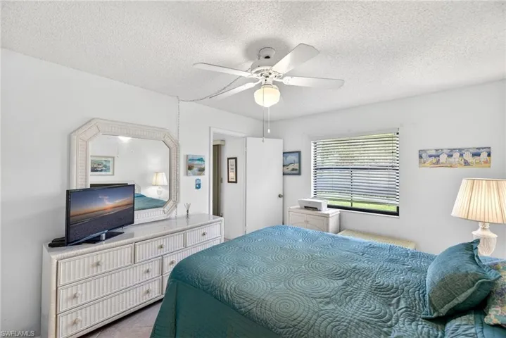Bedroom with a textured ceiling and a ceiling fan