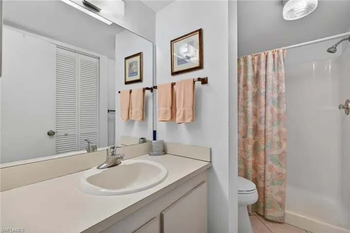 Full bathroom featuring vanity, a shower stall, a closet, and light tile patterned floors