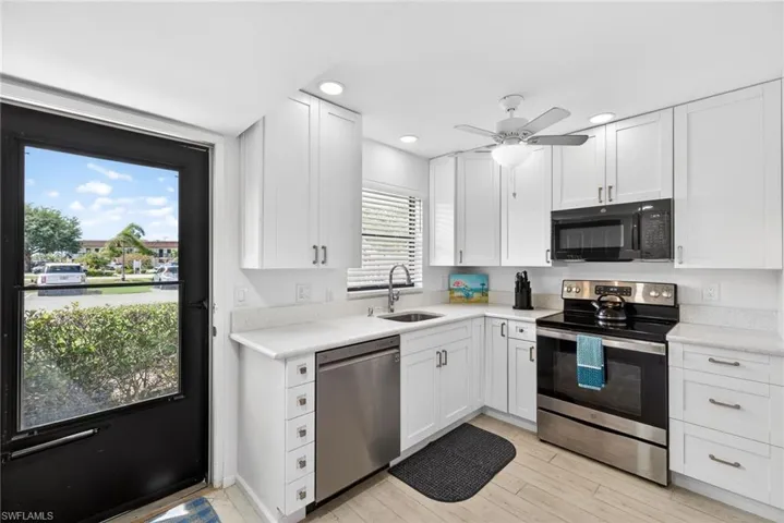 Kitchen with stainless steel appliances, white cabinets, a ceiling fan, recessed lighting, and light wood-style flooring