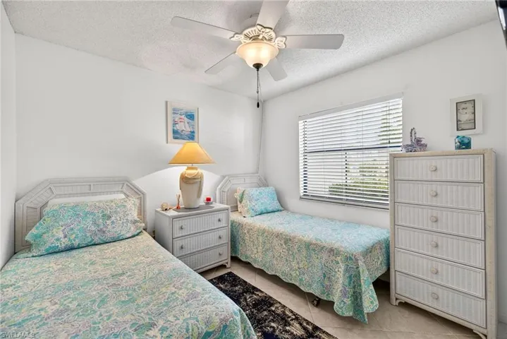 Bedroom featuring a textured ceiling, a ceiling fan, and dark tile patterned flooring