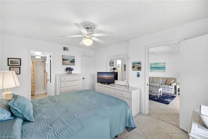 Bedroom with light tile patterned floors, a textured ceiling, and a ceiling fan