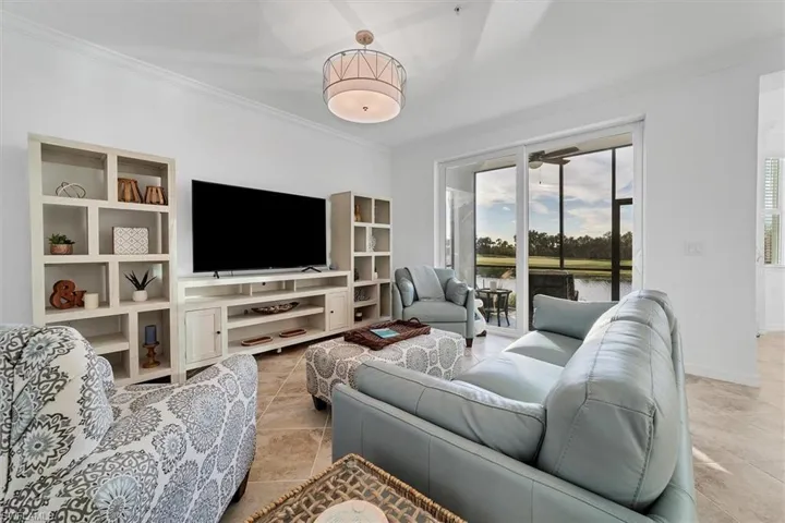 Living room with ornamental molding and light tile patterned floors
