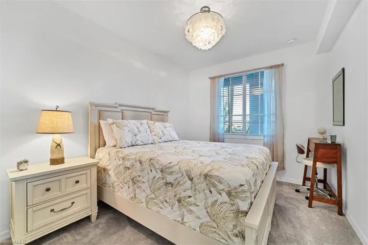 Bedroom with light colored carpet and baseboards