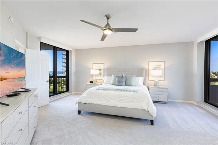 Bedroom featuring access to exterior, light colored carpet, ceiling fan, and floor to ceiling windows