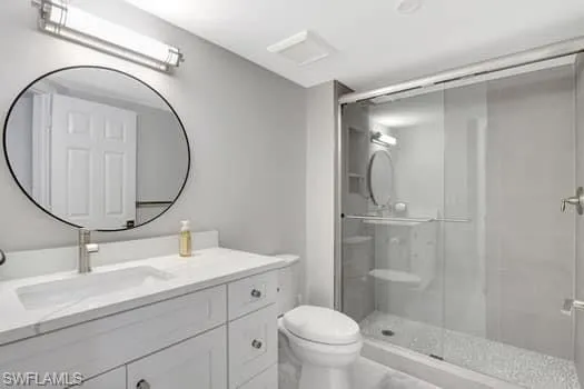 Bathroom with a stall shower, vanity, and toilet