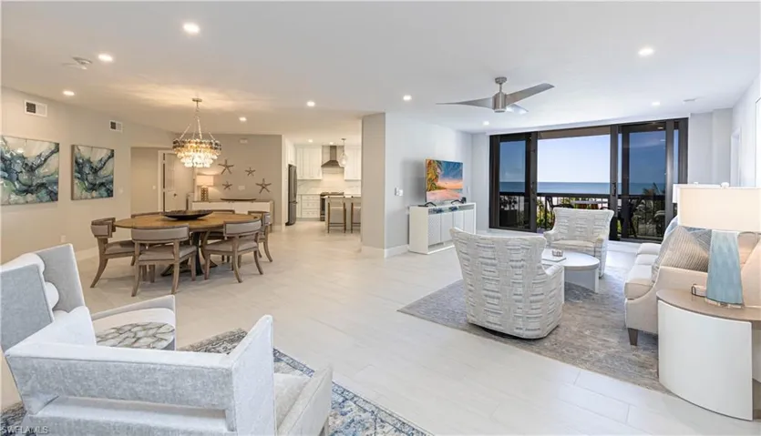 Living room featuring ceiling fan with notable chandelier