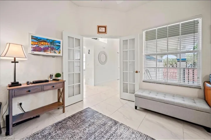 Sitting room with light tile patterned floors and french doors