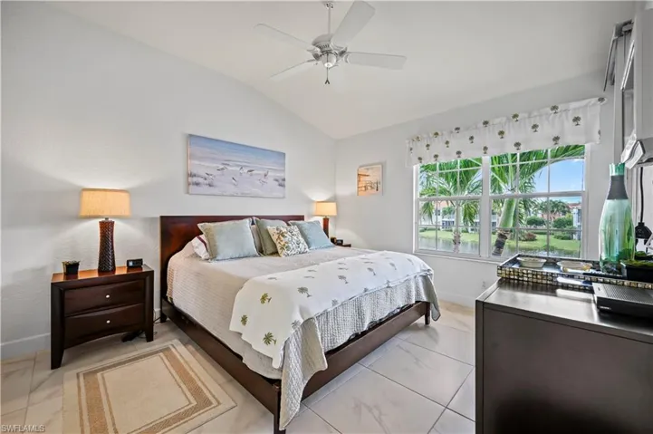 Tiled bedroom with ceiling fan and vaulted ceiling