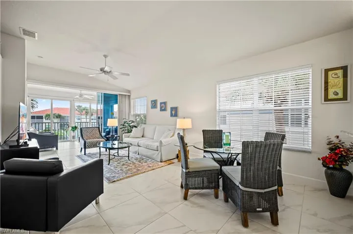 Living room with ceiling fan and light tile patterned floors