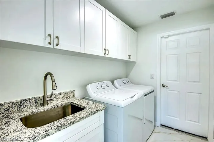 White shaker cabinetry with brushed nickel hardware, granite-style countertop, undermount stainless steel sink, and a gooseneck faucet