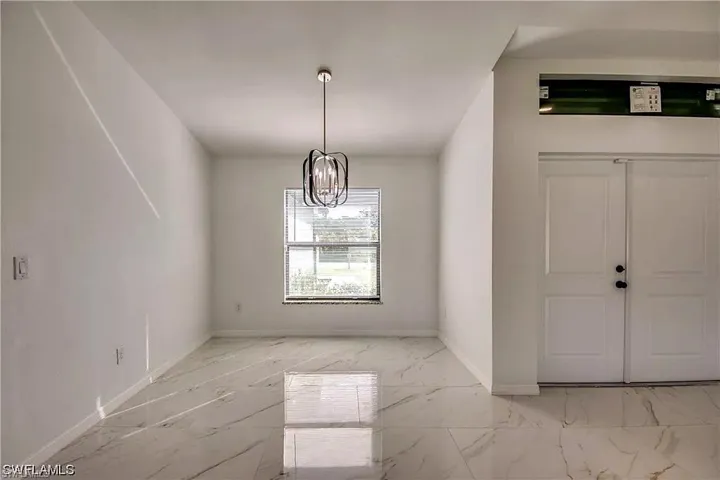 White walls, large format tile flooring, single window with blinds, and a contemporary ceiling fixture