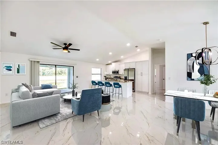 Vaulted ceilings, large format tile flooring, recessed lighting, and a modern ceiling fan