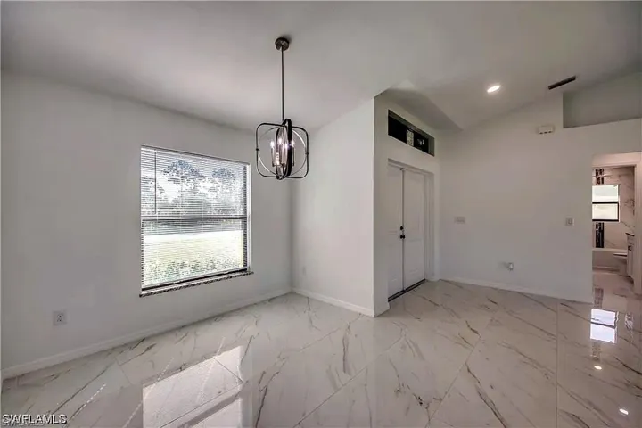Vaulted ceilings with recessed lighting, large window with horizontal blinds, decorative hanging light fixture, and white tile flooring