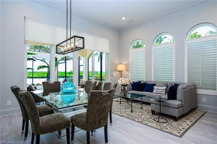 Dining area featuring light hardwood / wood-style flooring, ornamental molding, and a chandelier