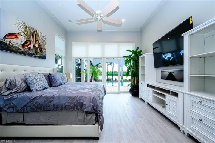 Bedroom featuring light hardwood / wood-style flooring, ceiling fan, ornamental molding, and access to outside