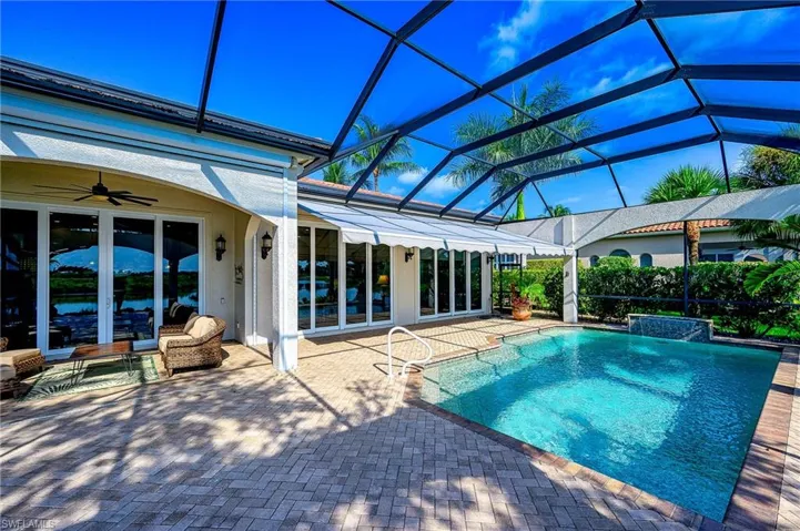 View of pool with glass enclosure, ceiling fan, a patio area, and french doors