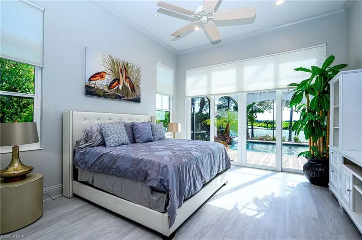 Bedroom with crown molding, light hardwood / wood-style flooring, ceiling fan, and access to outside