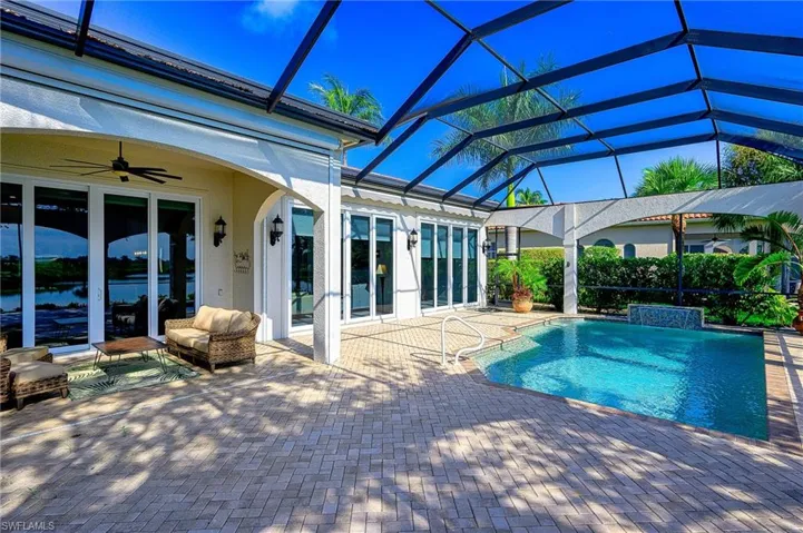View of swimming pool featuring ceiling fan, a lanai, and a patio area