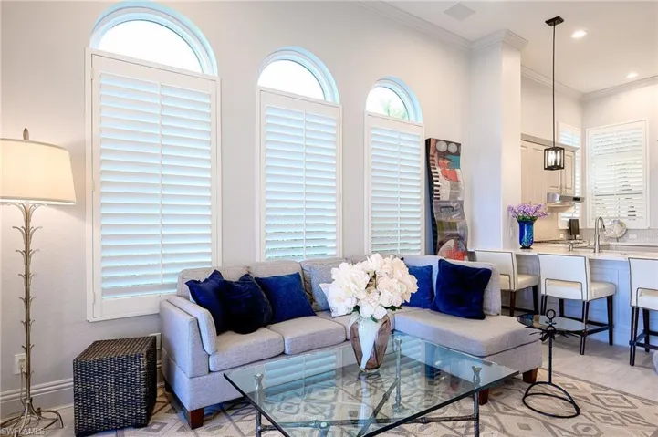 Living room featuring crown molding, light hardwood / wood-style flooring, and sink