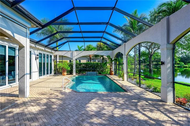 View of pool featuring a patio, a water view, and a lanai