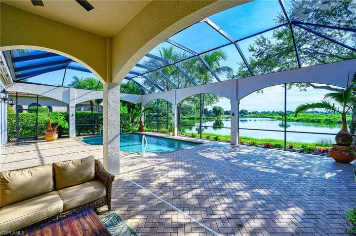 View of swimming pool featuring a patio, a water view, and a lanai