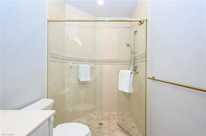 Bathroom featuring toilet, an enclosed shower, and vanity