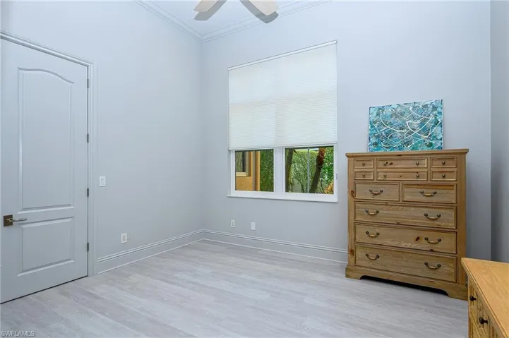 Unfurnished bedroom with ceiling fan, crown molding, and light hardwood / wood-style floors