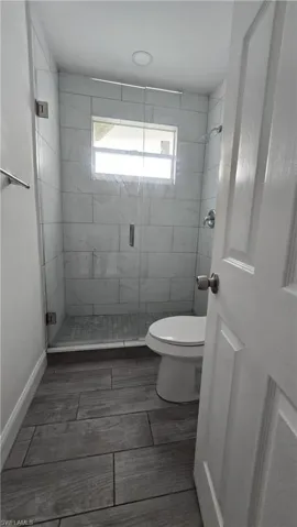 Bathroom with a shower stall and toilet