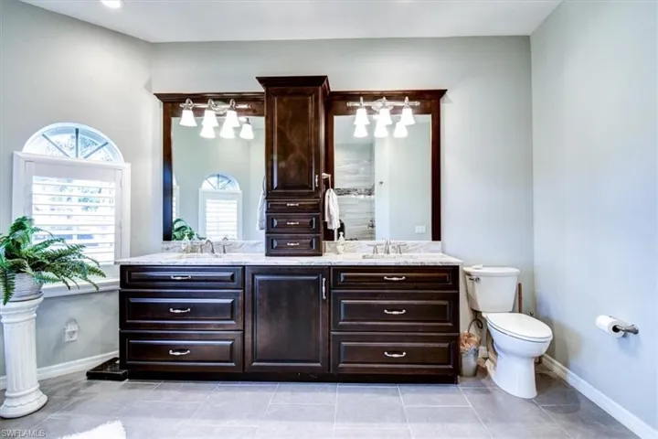 Full bathroom featuring double vanity and light tile patterned flooring