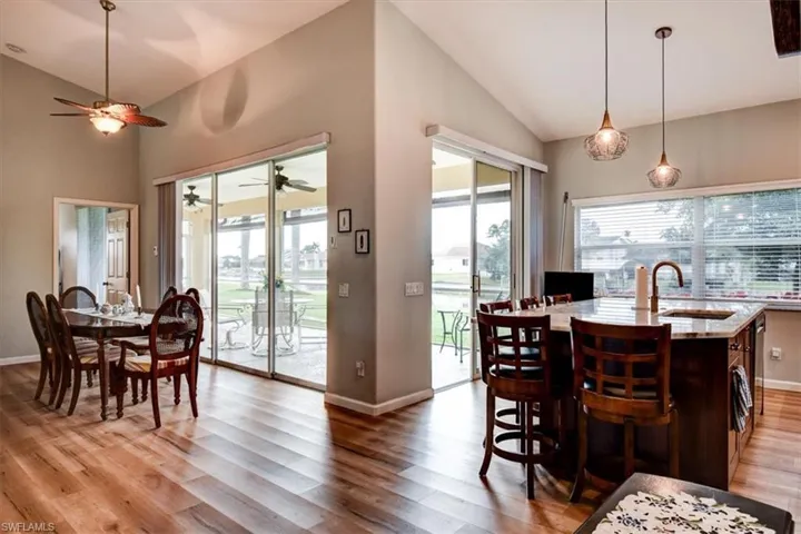 Dining area with vaulted ceiling and light wood-style flooring