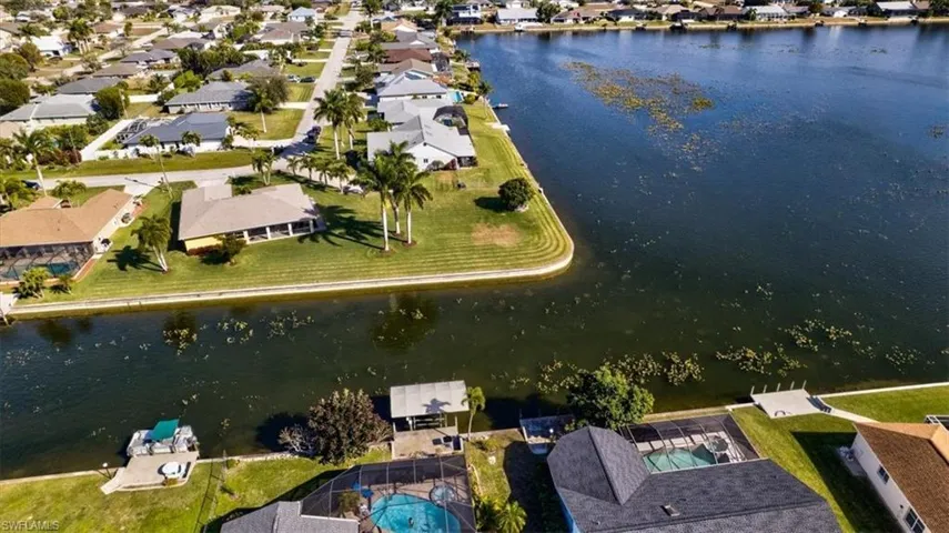 Aerial view of property and surrounding area with nearby suburban area and a nearby body of water