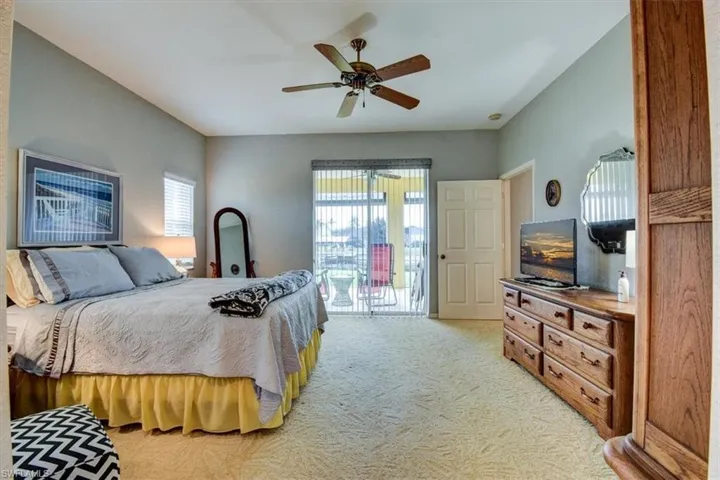 Bedroom featuring light carpet, a ceiling fan, and access to outside