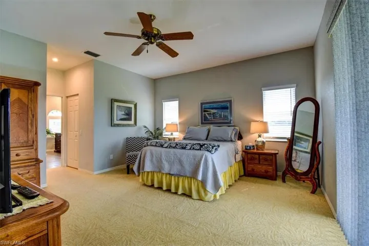 Bedroom with light carpet, multiple windows, ceiling fan, and recessed lighting