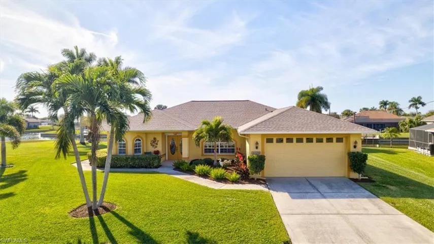 View of front of house featuring a front lawn, driveway, a garage, and stucco siding