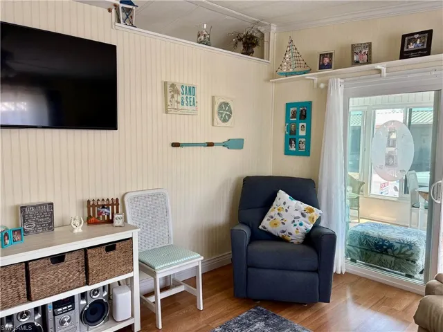 Living area featuring wood finished floors and ornamental molding