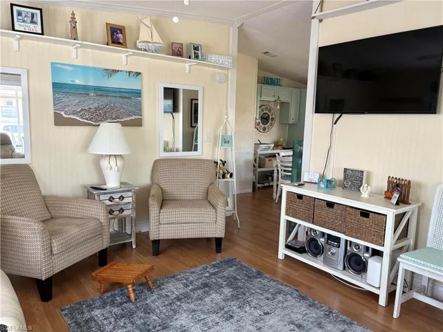 Sitting room with vaulted ceiling and wood finished floors