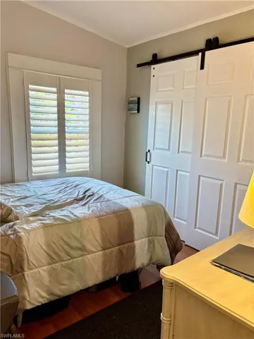 Bedroom with a barn door and wood finished floors