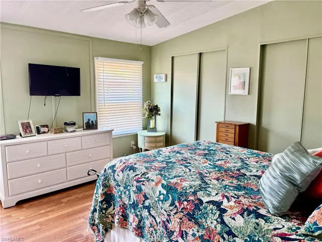 Bedroom featuring light wood-type flooring, two closets, and ceiling fan