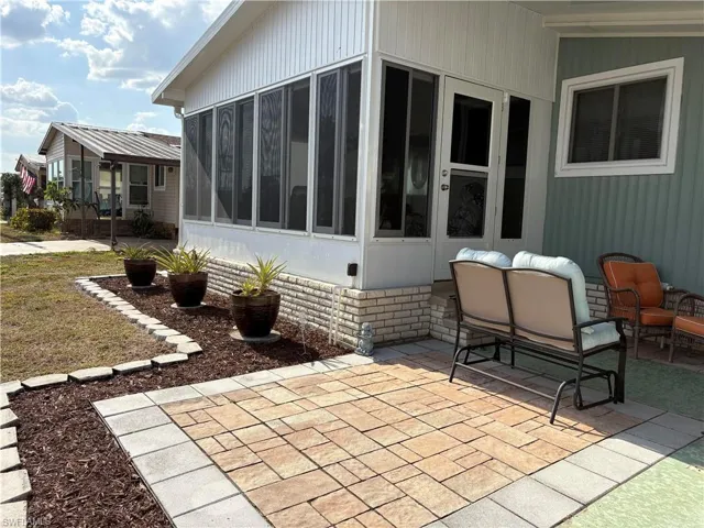 View of property exterior featuring a sunroom and a patio