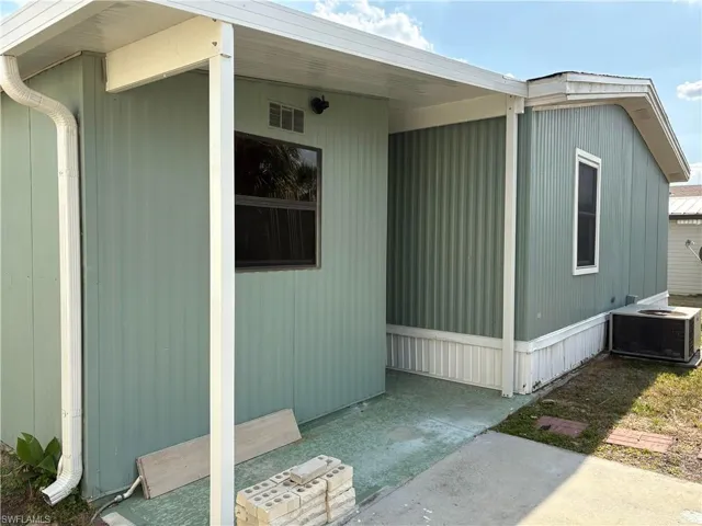 View of side of home featuring cooling unit