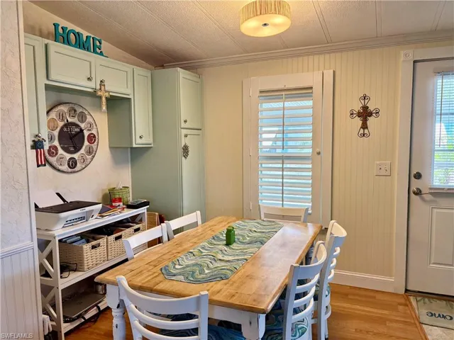 Dining space with light wood-style floors and crown molding