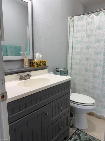 Full bath with tile patterned floors, vanity, and toilet
