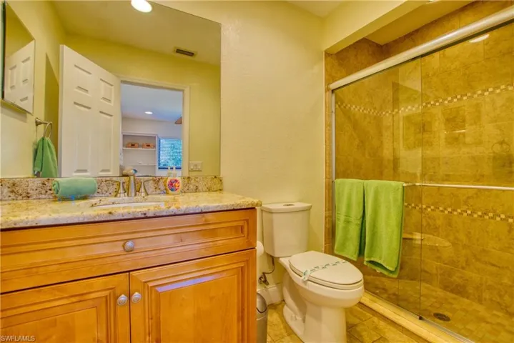 Full bath with vanity, a stall shower, light tile patterned floors, and recessed lighting