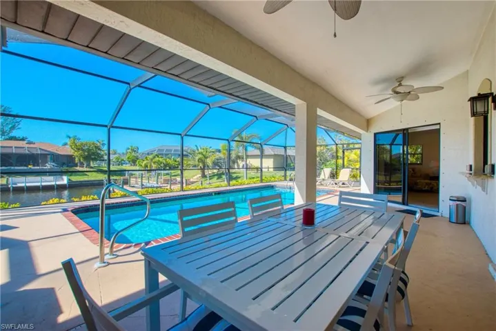Outdoor pool featuring a patio area, a sunroom, a lanai, and ceiling fan