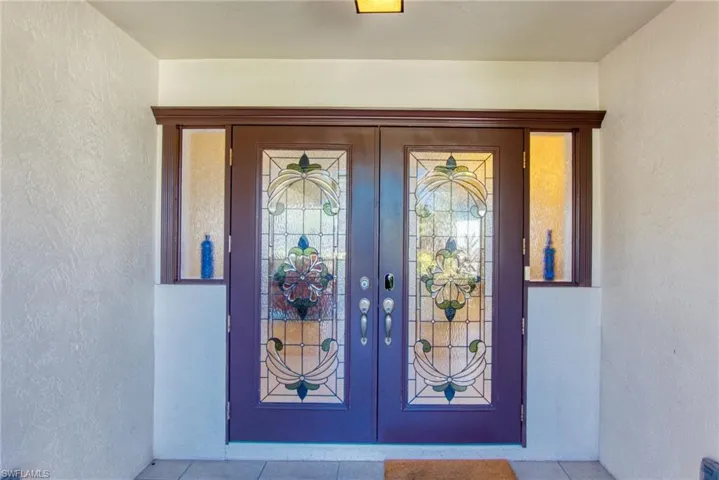 Property entrance featuring stucco siding and french doors
